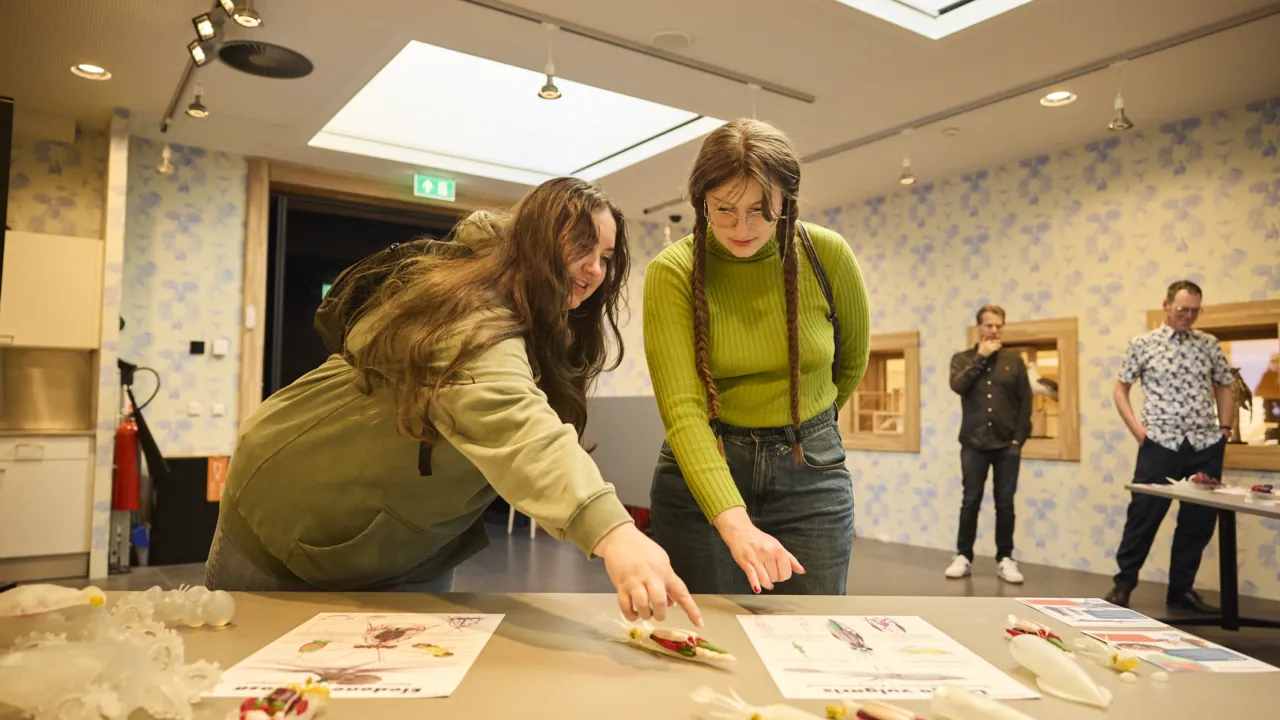 Twee docenten in opleiding bij een tafel met informatie