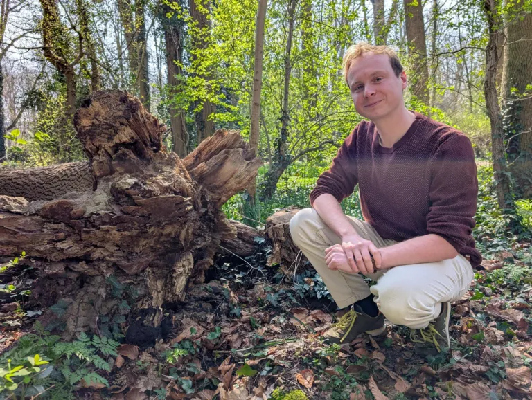 Foto van Sjoerd naast een omgevallen boom.
